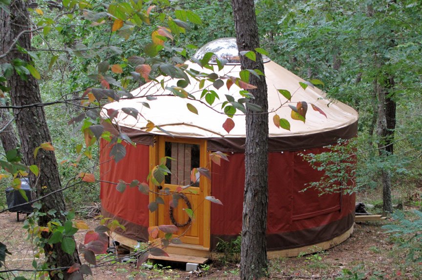 A 16 foot yurt on a platform in a forest clearing